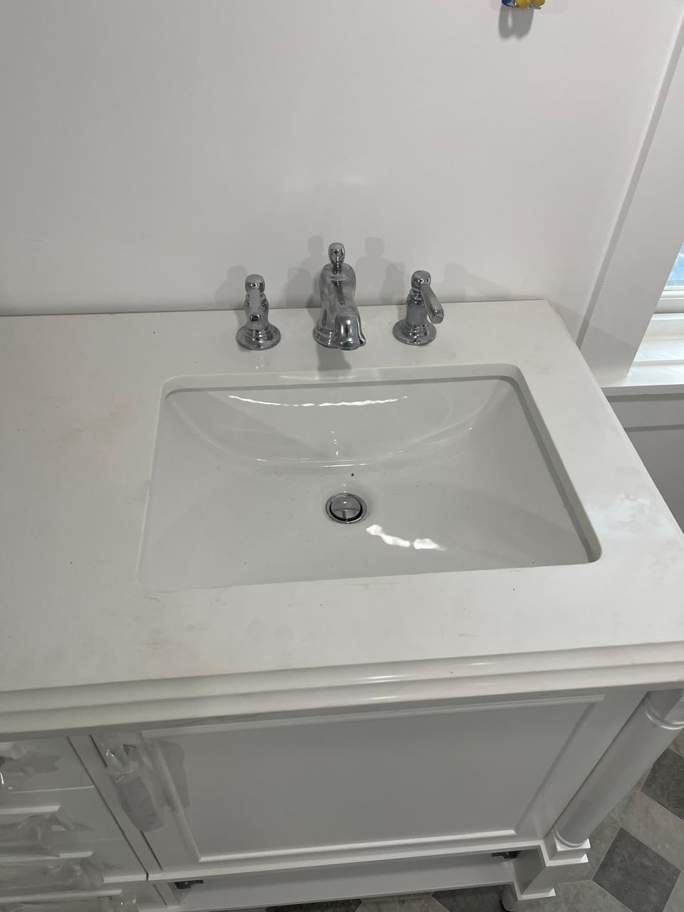 Finished faucet and drain installation in bathroom basin