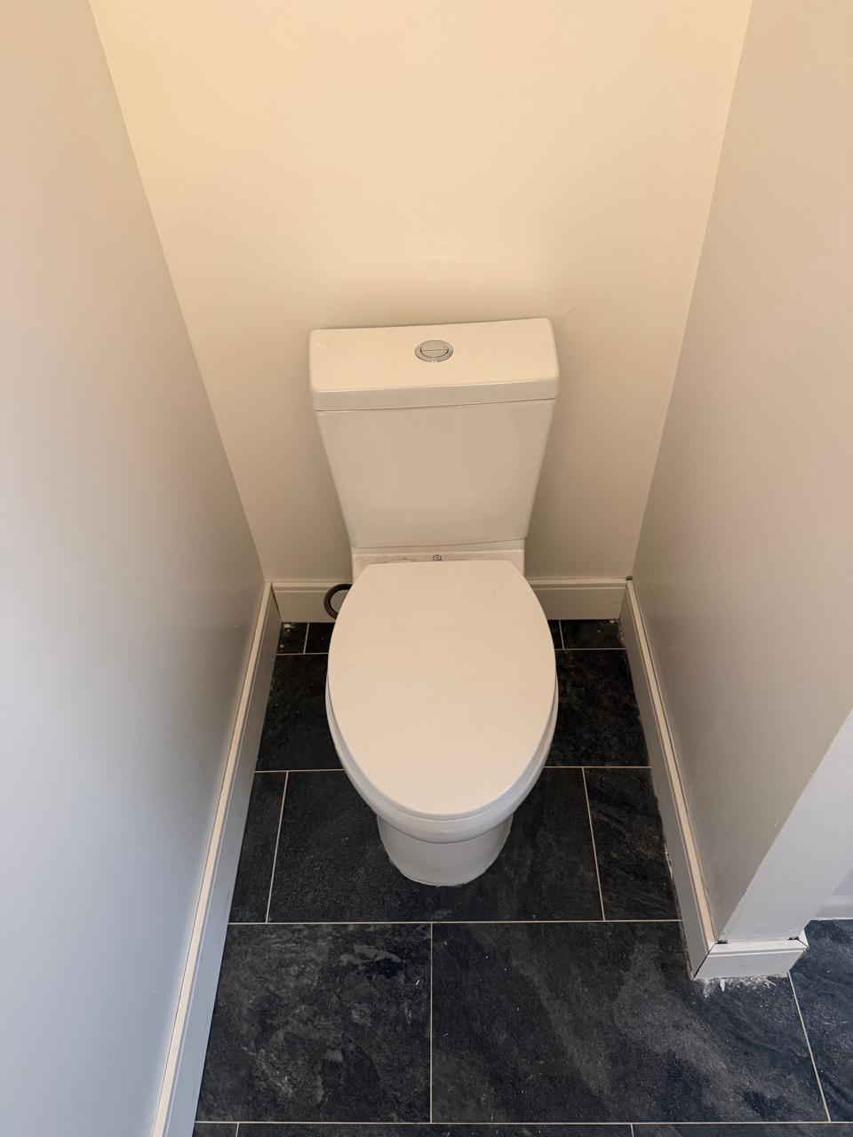 Finished bathroom toilet installation with completed plumbing connections