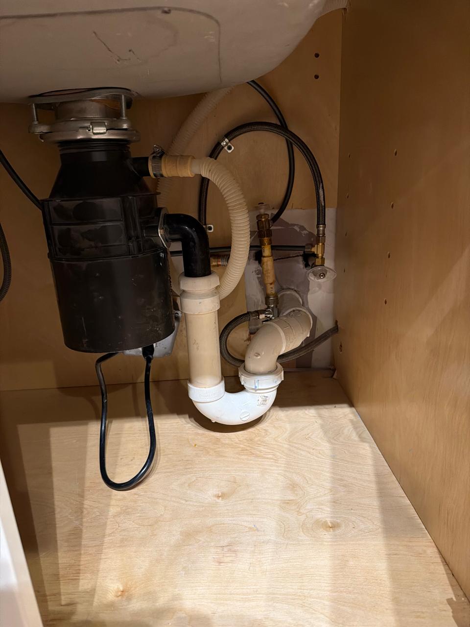 Finished kitchen plumbing with P-trap and ice maker water line installation